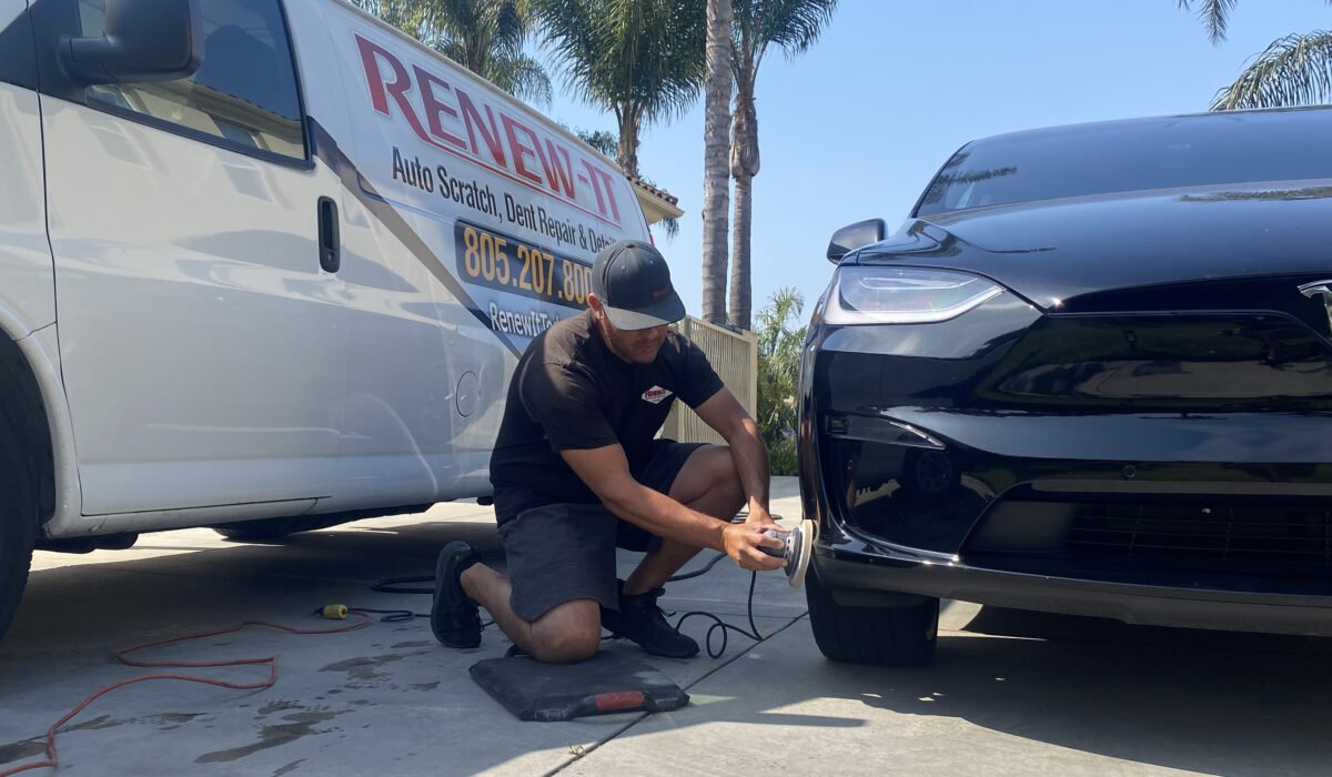 Man detailing a black Tesla car